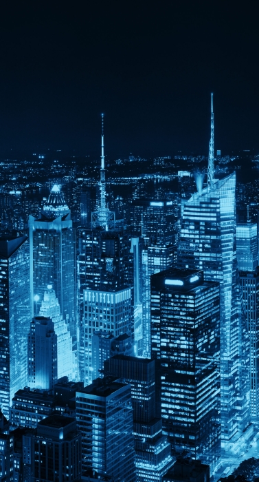 New York City midtown skyline with skyscrapers and urban cityscape at night.